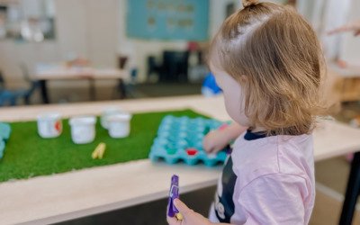 Child developing fine motor skills playing with a peg at Active Explorers preschool central city Christchurch