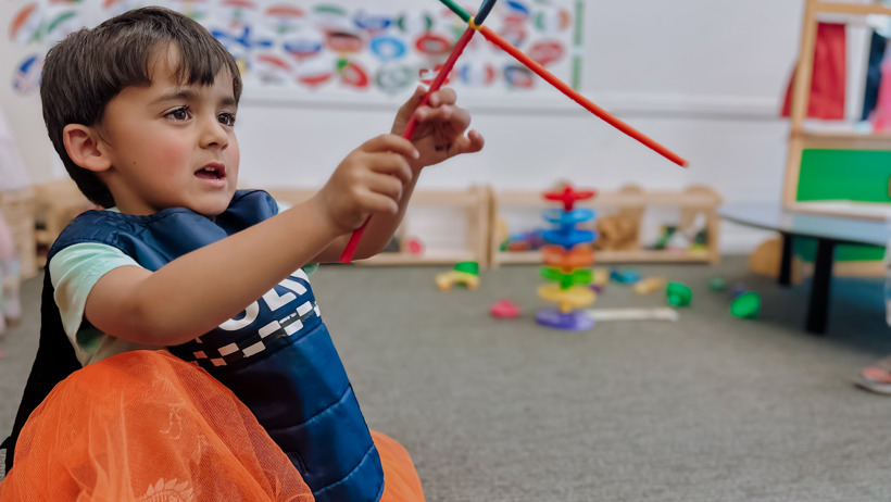 Child playing with a straw creation made at Active Explorers preschool in Christchurch