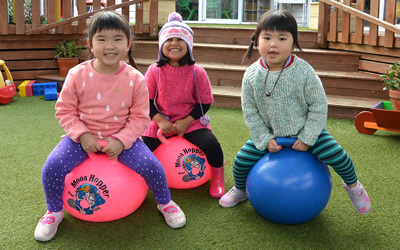 three girls on hoppers at daycare