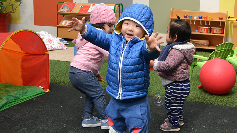 boy with arms outstretched at daycare