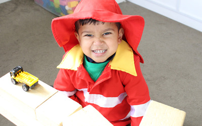 boy smiling with truck and blocks at preschool