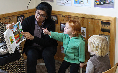 teacher reading a book to children at daycare
