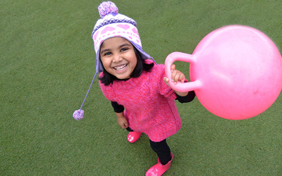 happy girl with pink toy at daycare