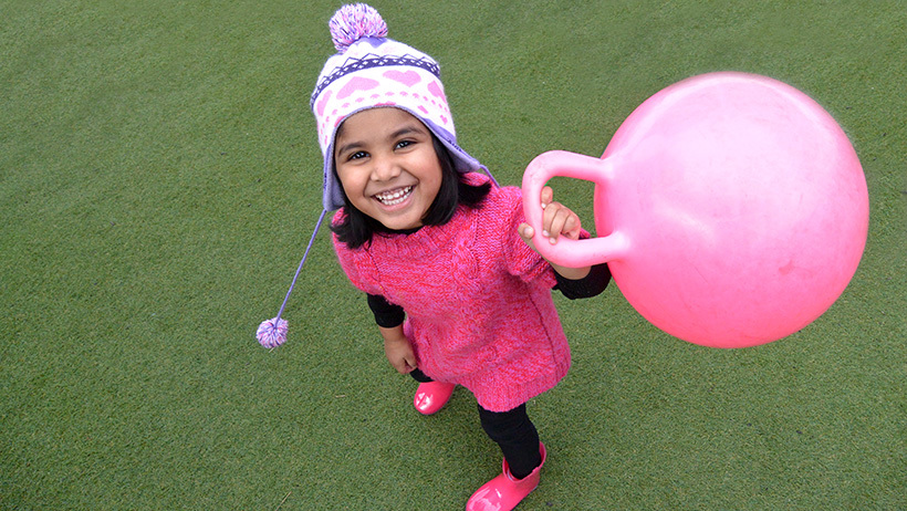 happy girl with pink toy at daycare