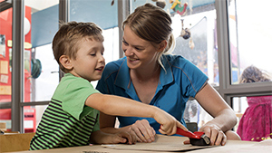 teacher and child at daycare centre doing an activity together